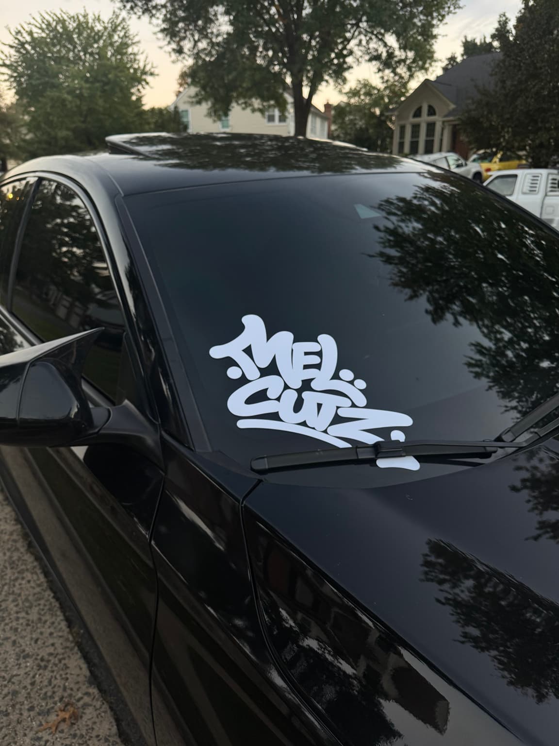 White vinyl windshield decal installed on a black car by JAV Customs